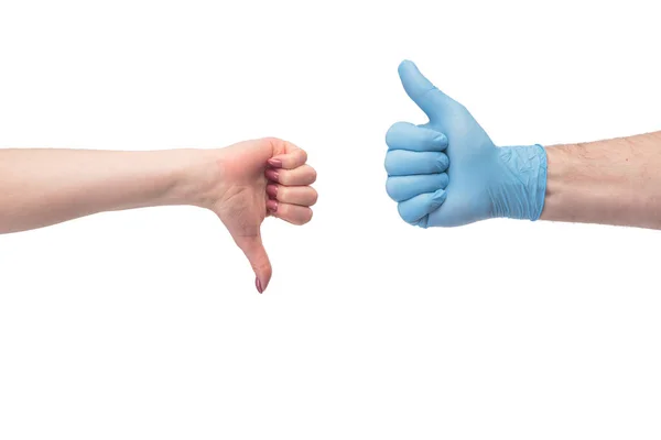 Hand in gloves thumb up and without thumb down over white background Stock Photo