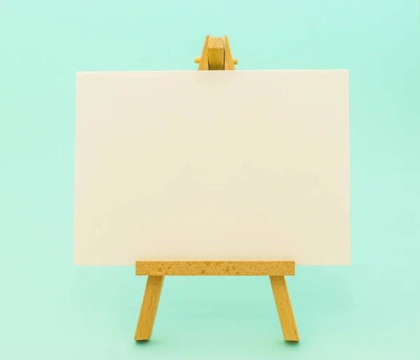 Küçük şövale üzerinde renkli arka plan üzerinde beyaz kağıt