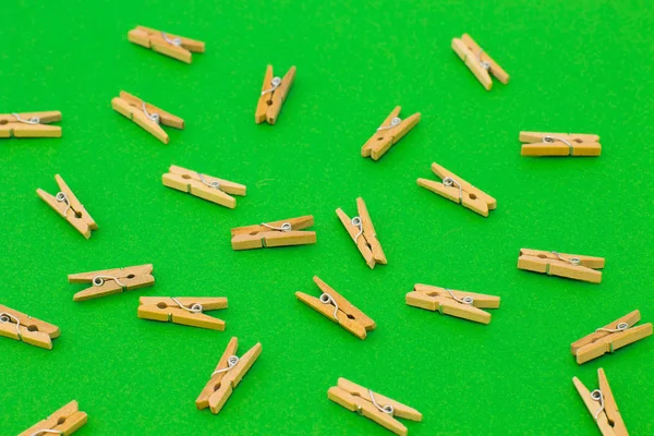 Parlak yeşil zemin üzerine ahşap clothespins kümesi