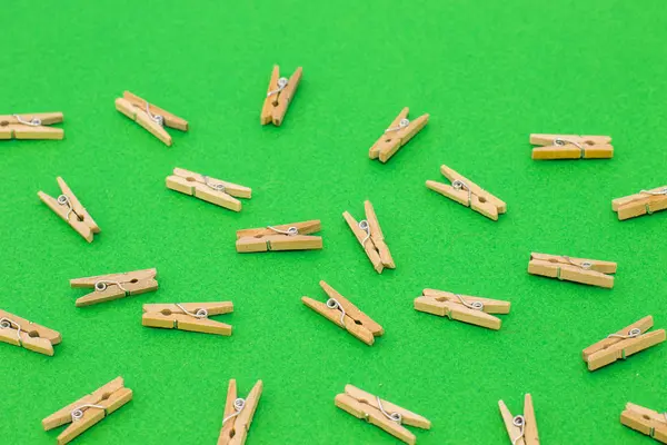 Parlak yeşil zemin üzerine ahşap clothespins kümesi