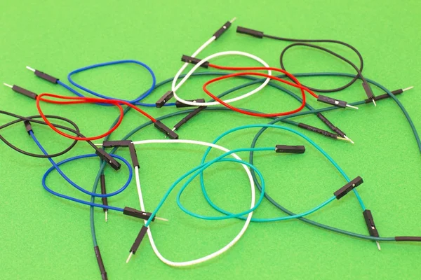 Yeşil arka plan üzerinde renkli kablolar kümesi