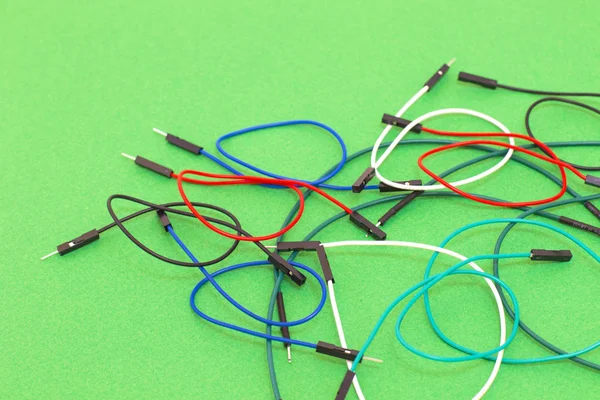 Yeşil arka plan üzerinde renkli kablolar kümesi