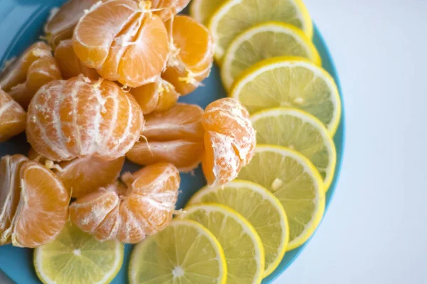 Mavi plaka dilimlenmiş limon ve mandalina