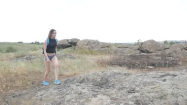 Kız turist kayaların üzerinde yürüyor