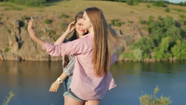 Duas namoradas a tirar fotografias no parque. Meninas selfie ao ar livre . — Vídeo de Stock