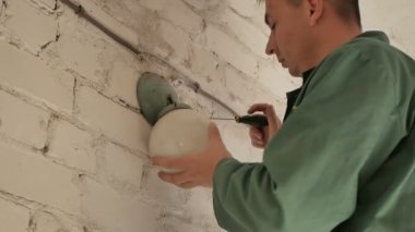 Elektrikçi onarır eski Duvar lambası