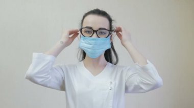 Bir hemşire yüz maskesi takıyor. Salgın durumu. Coronavirus veya COVID19.