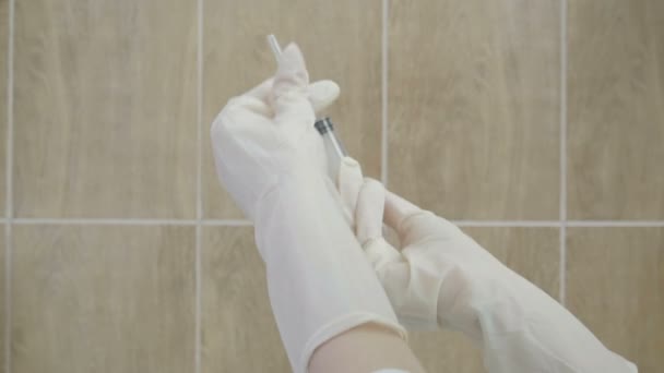 Seorang dokter wanita mengambil jarum suntik. Close-up. Situasi epidemi . — Stok Video
