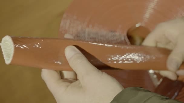 Mens handen houden een scheef niet-ontvlambaar weefsel vast — Stockvideo