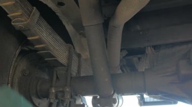 Bir tamirci ingiliz anahtarı kullanarak araba tekerleğini tamir ediyor..