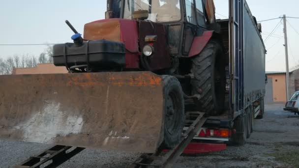 L'escavatore del trattore si tuffa su una lunga piattaforma di camion — Video Stock