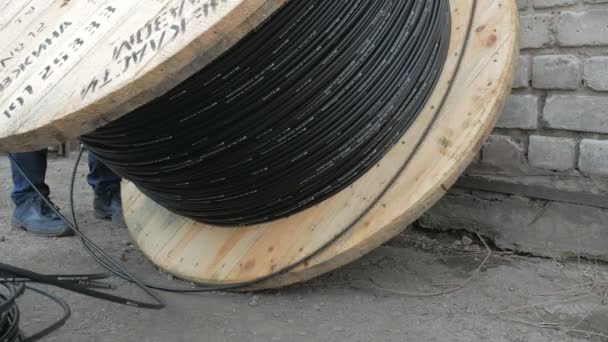 Close-up. cabo de fibra óptica em um grande carretel de madeira. — Vídeo de Stock