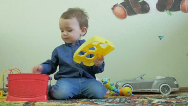 Ребенок играет с мамой игрушки сидя на полу — стоковое видео