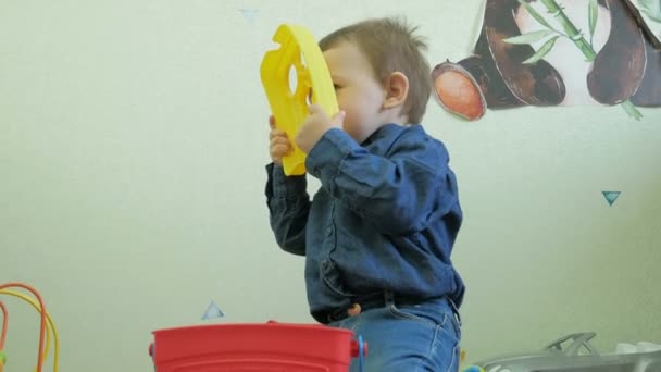 Een kind speelt met mama speelgoed zitten op de vloer — Stockvideo