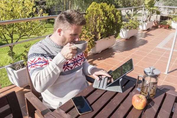 Mutlu adam bahçede kahvaltı ile teknoloji