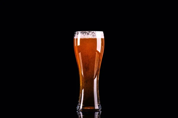 黒い背景に泡とビールのグラス — ストック写真