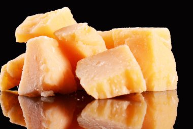 Yansıma bir siyah parlak masada parmesan peyniri. Siyah arka plan üzerine izole Parmesan peyniri.