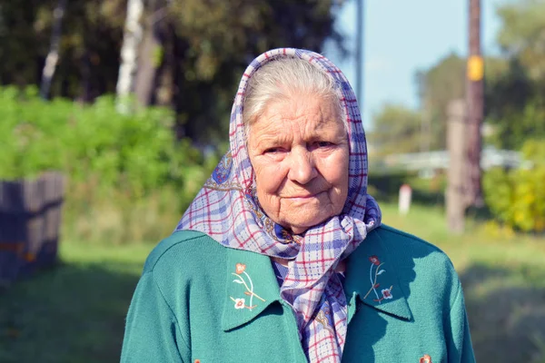 Bir eşarp yaşlı bir kadın. Yalnız yaşlı bir köyde duran kadın portresi
