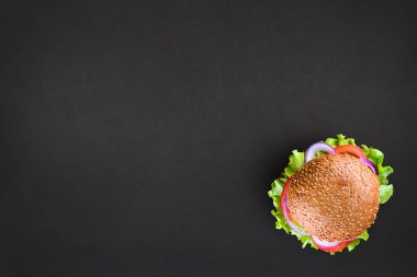 Taze lezzetli burger üst siyah arka plan üzerine görüntüleyin. Lezzetli ve iştah açıcı çizburger. Metin için yer ile vejetaryen burger