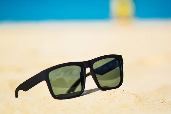 Fashion sunglasses on sea beach. Summer holiday relax background with copy space — Stock Photo, Image
