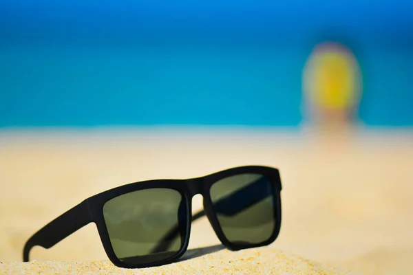 Модні сонцезахисні окуляри на березі моря. Літні канікули розслабляють фон з місцем для тексту — стокове фото