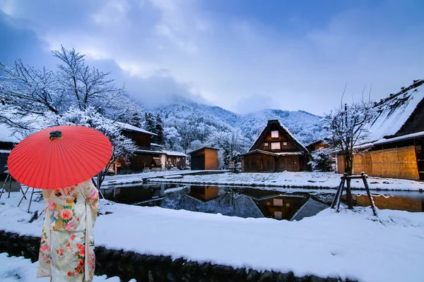 Winter Shirakawago ve Gifu Chubu Japonya. Kırmızı şemsiyeli yukata giyen bir kız..