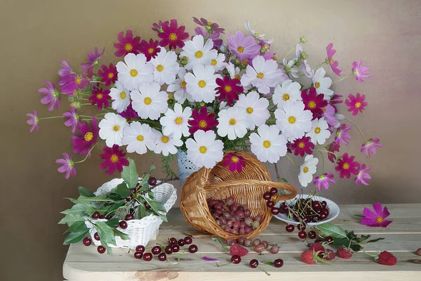 Bodegón con un ramo de hermosas flores y una cesta de bayas — Foto de Stock