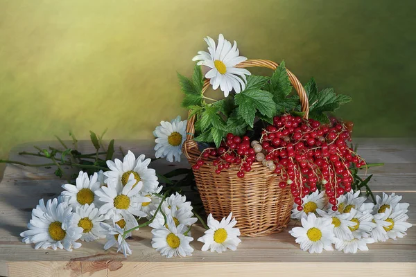 Flores silvestres em um vaso e bagas na cesta . — Fotografia de Stock