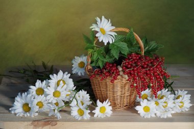 Kır çiçekleri ve olgun, kırmızı çilek bir sepet içinde. 