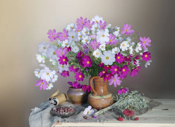 Fehér virágok a vázában és érett bogyók ecset a barna háttér — Stock Fotó