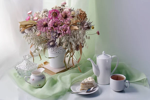 Stilleven met bloemen, kopje thee en cake. — Stockfoto
