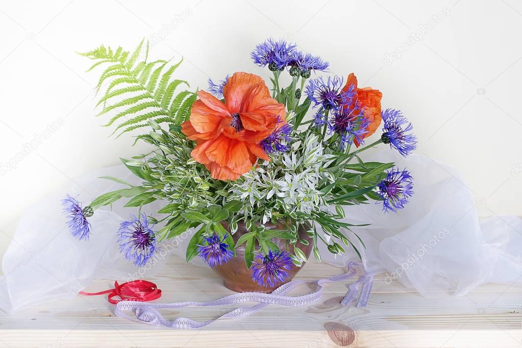  Bouquet of poppies and cornflowers in vase