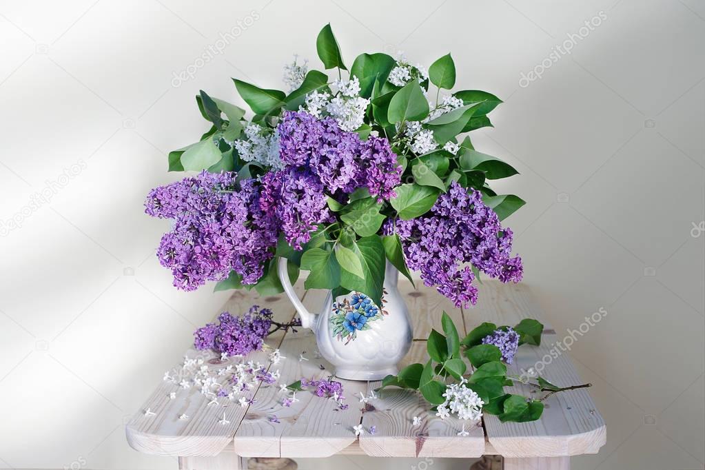  A bouquet of lilacs.Still life of beautiful flowers cultivated in a vase on light background