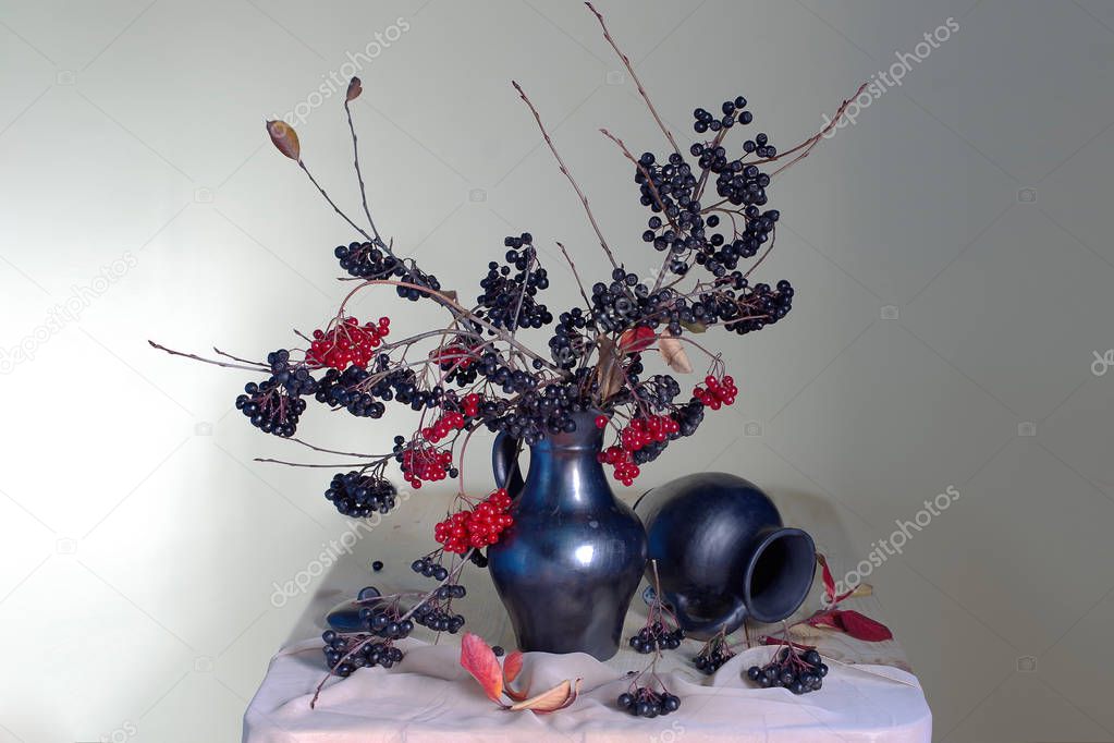 Autumn still life berries fireplaces, yellow leaves in a vase on a brown background.