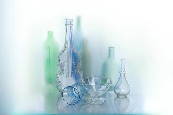 Glass vases and bottles interesting lying on the window sill isolated on light background.