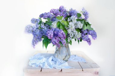 Beyaz bir arka plan üzerinde izole bir masa üzerinde bir vazo içinde natüralak çiçekler.