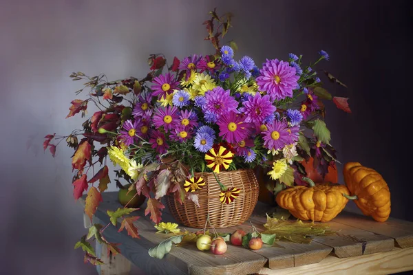 Bouquet of different flowers and ripe apples.Autumn still life with flowers and apples.