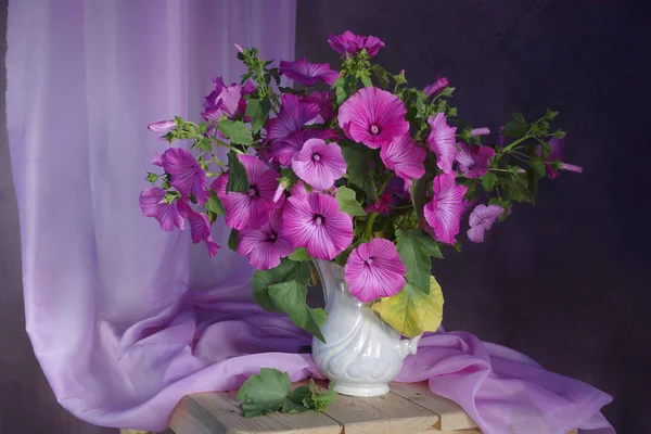 Still life with pink flowers in vase isolated on brown background.Summer flowers in a bouquet in pink tones.