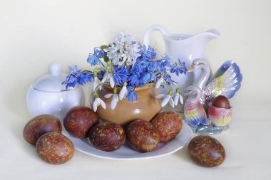 Dekoratif paskalya yumurtaları ve kar damlaları beyaz arka planda izole edilmiş..