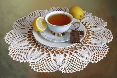 Masadaki beyaz peçeteye bir fincan sıcak çay ve limon..