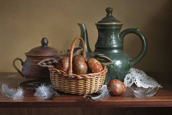 Chicken egg in a basket, feathers . Easter still life in the old style .