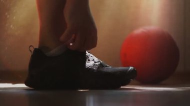 Atlet spor ayakkabı ve bağlama ayakkabı bağcığı giyer