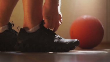 Atlet spor ayakkabı ve bağlama ayakkabı bağcığı giyer