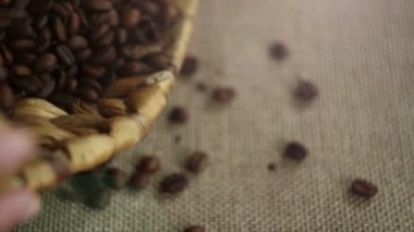 Kahve çekirdekleri bir sepet dışarı dökülmesini. Adam masada kahve çekirdekleri ortaya konuyor