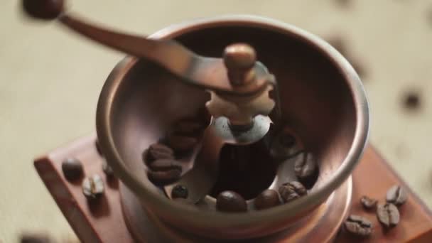 Broie des grains de café avec un vieux moulin à café 