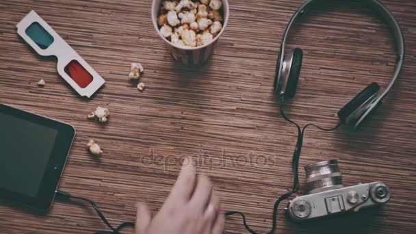 Un hombre toma una taza de cartón con palomitas de maíz, vista superior — Vídeos de Stock