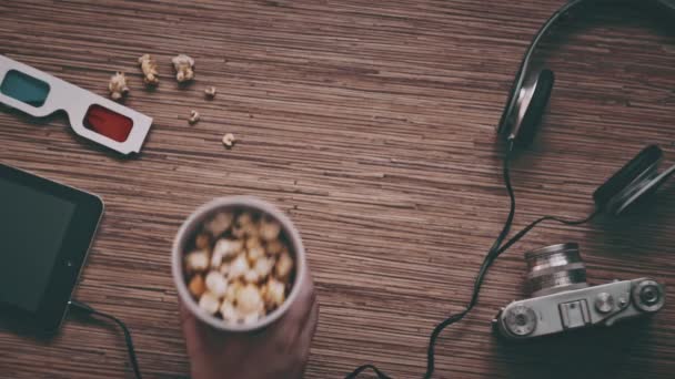 Man puts cardboard cup with popcorn, top view — Stock Video