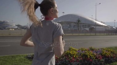 Sabahın erken saatlerinde koşu bir genç kız. Arka planda, Sochi şehir tesislerinde spor