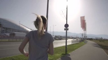 Sabahın erken saatlerinde koşu bir genç kız. Arka planda, Sochi şehir tesislerinde spor