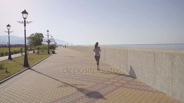 The girl is running. Slow motion. A young girl jogging in the early morning. — Stock Video